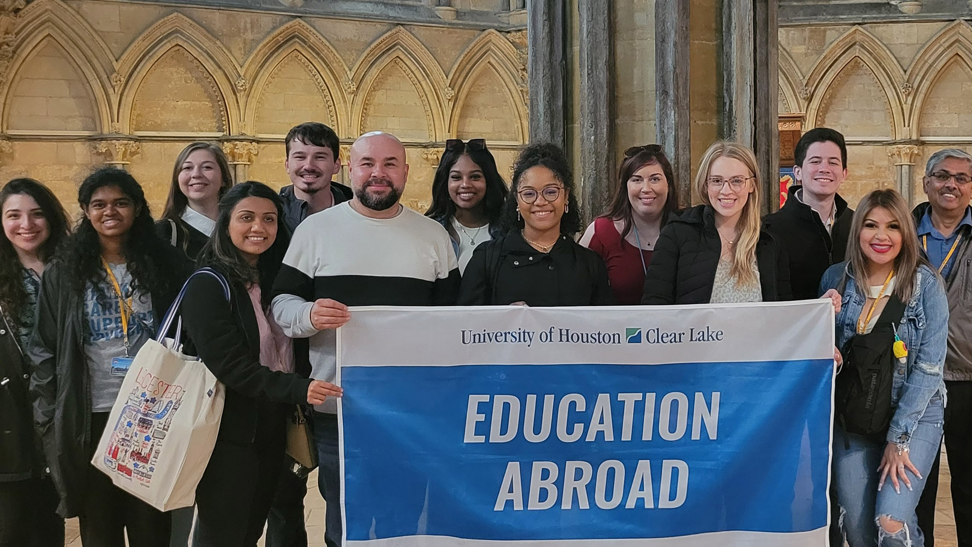 Healthcare Administration students holding the UHCL Education Abroad flag on 2022 U.K. study abroad trip