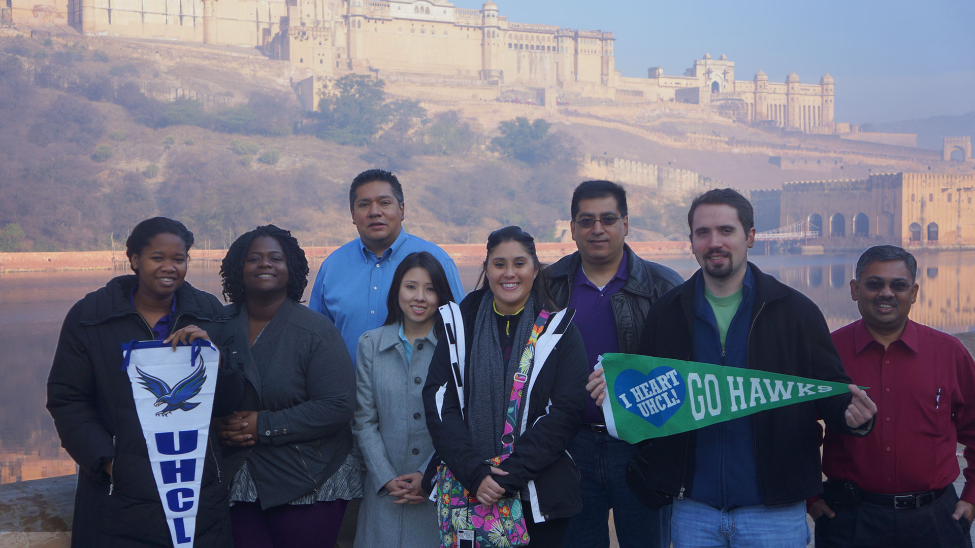 Students holding UHCL penants in Oman