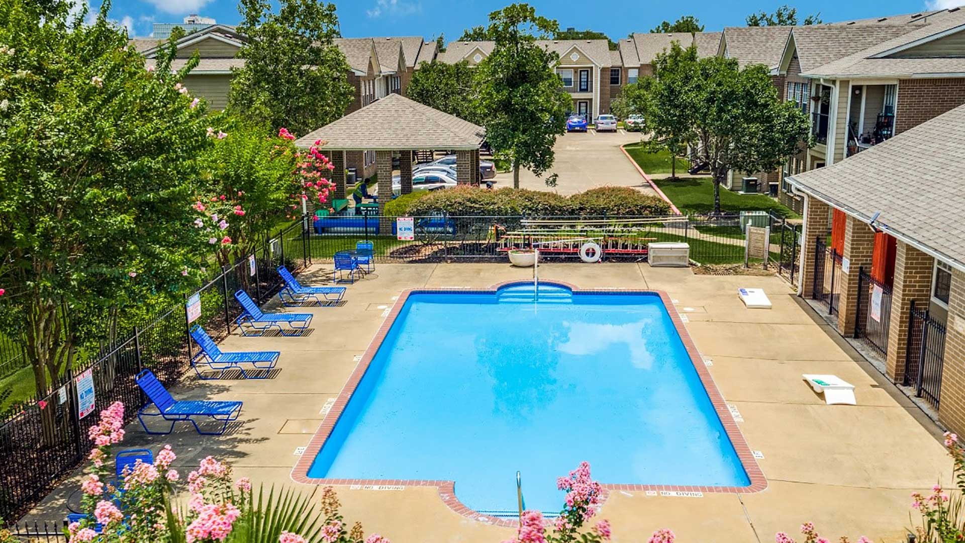 The University Forest Apartments complex and pool area.