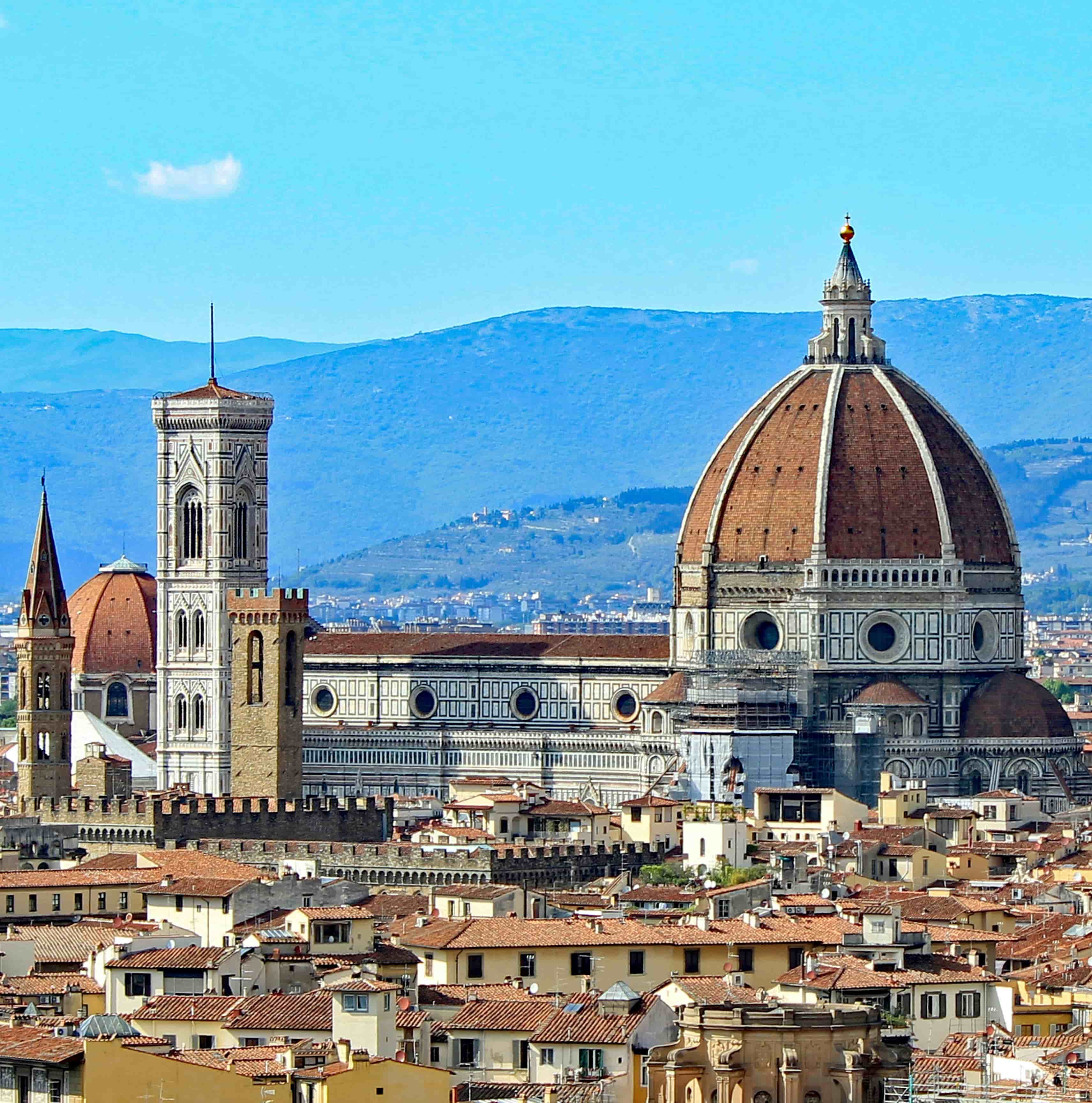 a large building stands tall right in the center of the bustling tuscany city