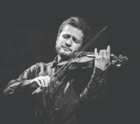 A black and white image of a male violinist performing soulfully.