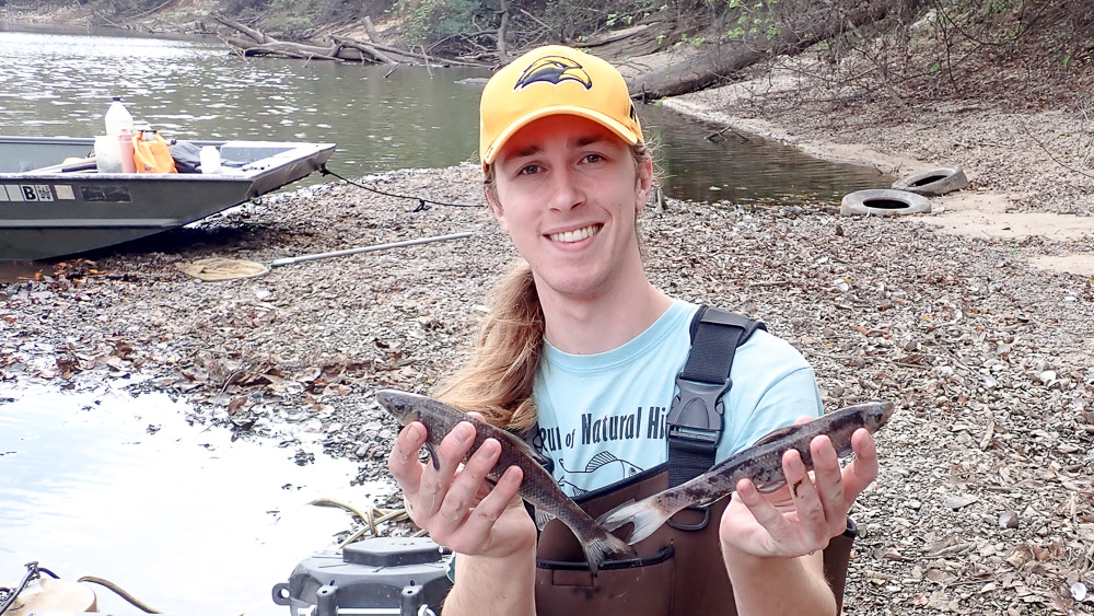 Noah Daun Noah holds two fish as he smiles to the camera