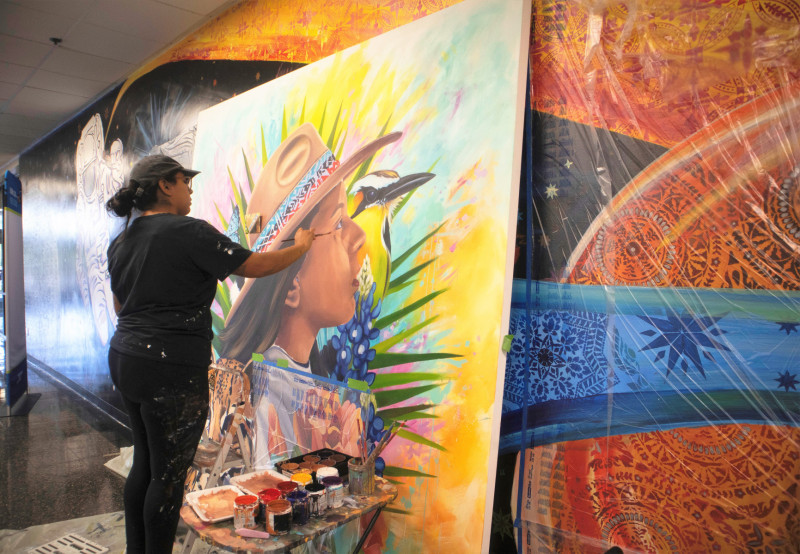 UHCL alumna Elizabeth Unmazor working on her painting, 'The Explorer.'