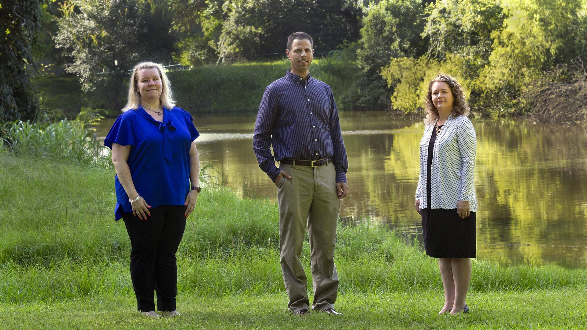 Three faculty members next to UHCL's Potter Pond.
