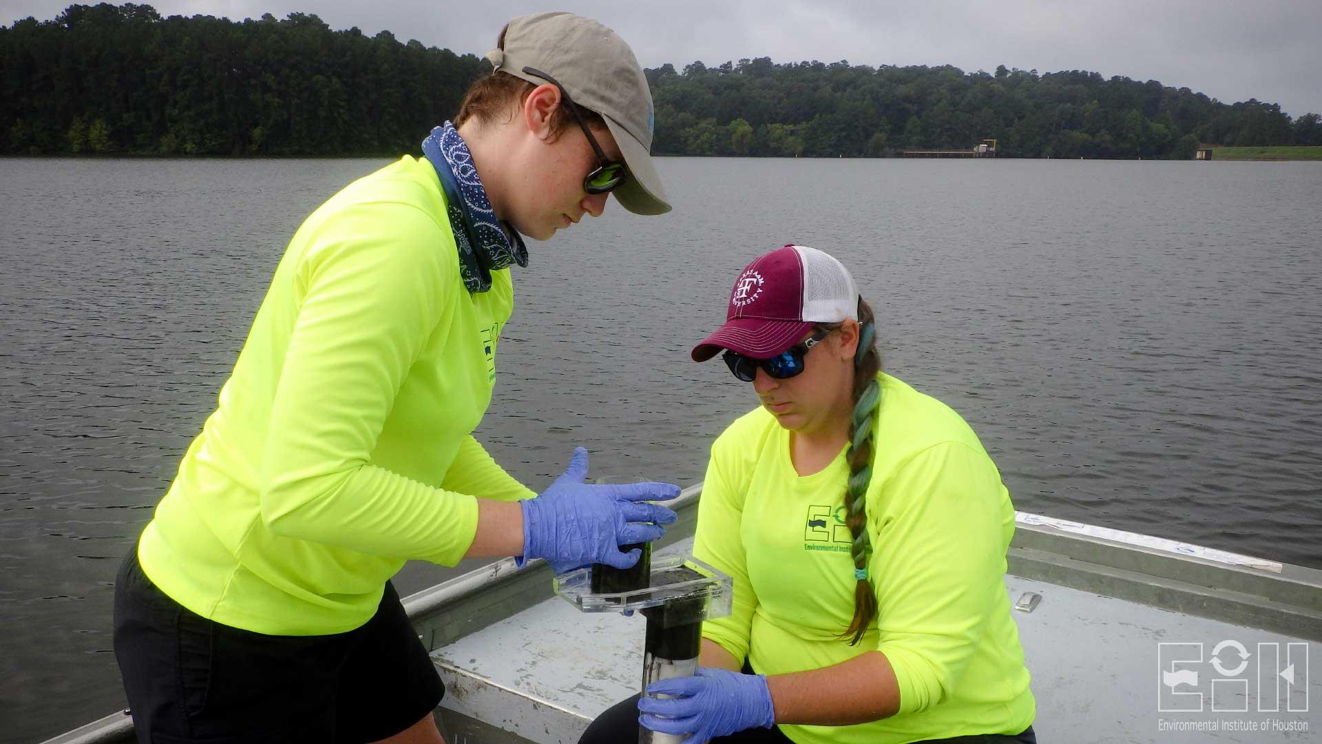 Jo Vaughn and Emily Miller, lentic ecology technicians, take a core sample in Pinkston Reservoir.