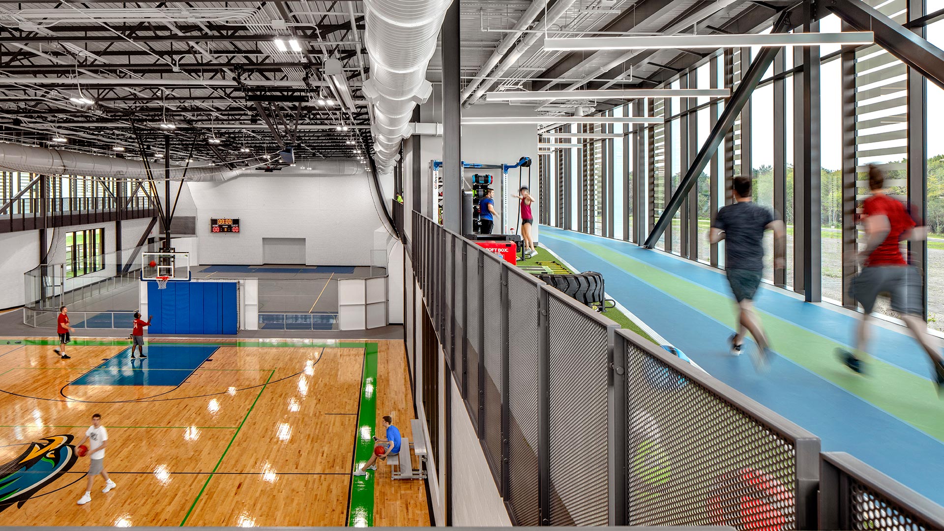 Students running on the indoor track and playing on a basketball court