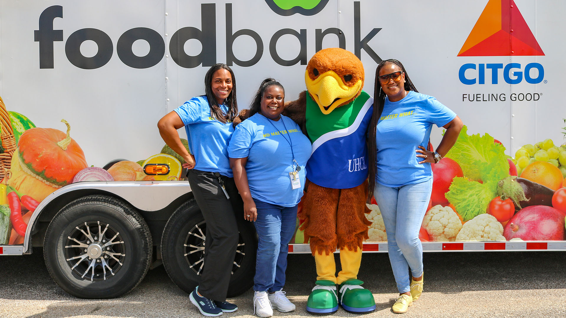 The OSA staff and Hunter Hawk gathered in front of a Houston Food Bank truck