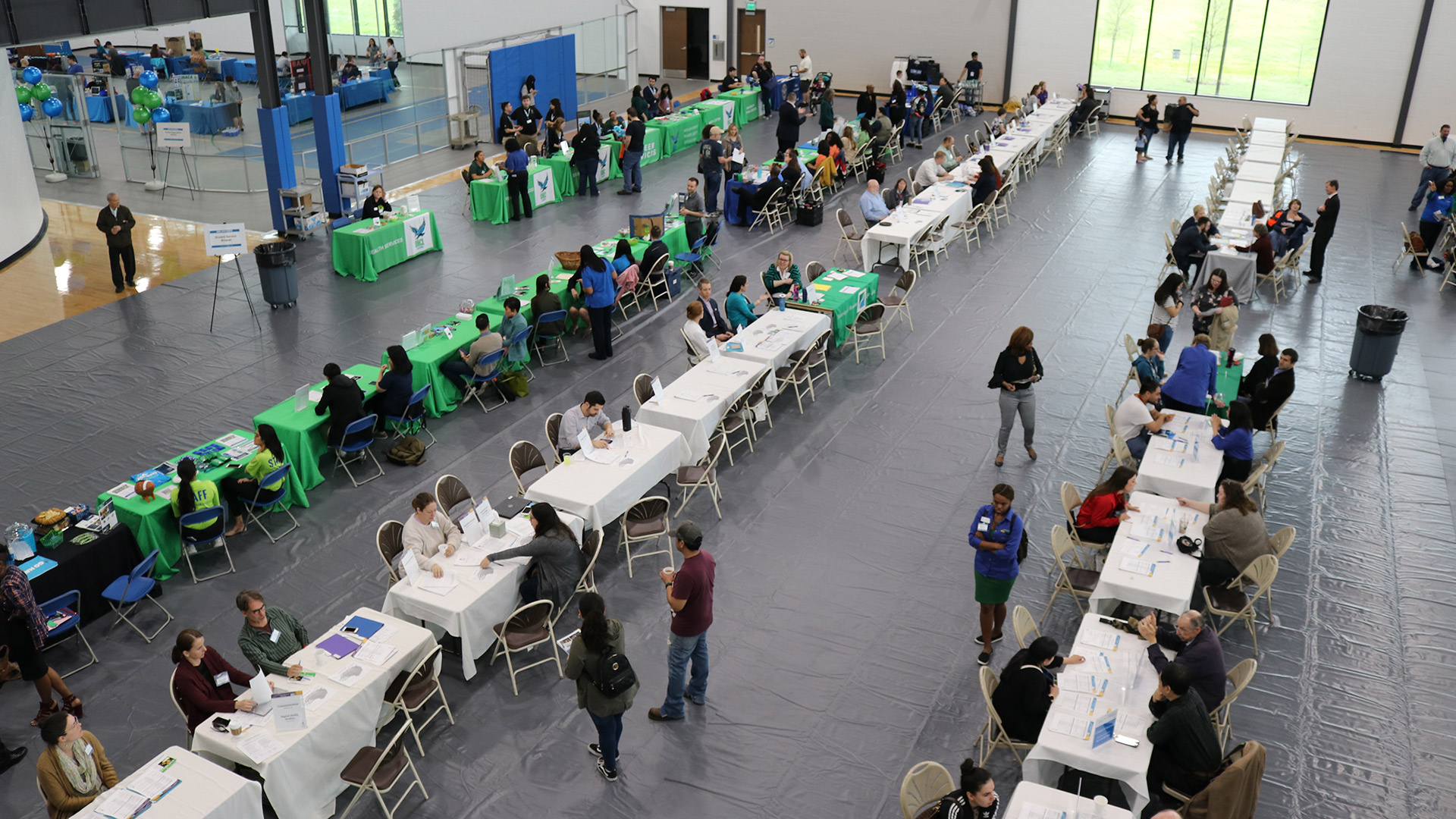Rows of busy tables at an event in the Multi-Activity Court, or MAC Gym.