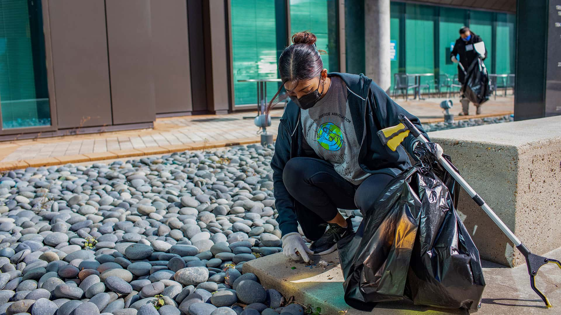 Student gathering litter at Alumni Plaza