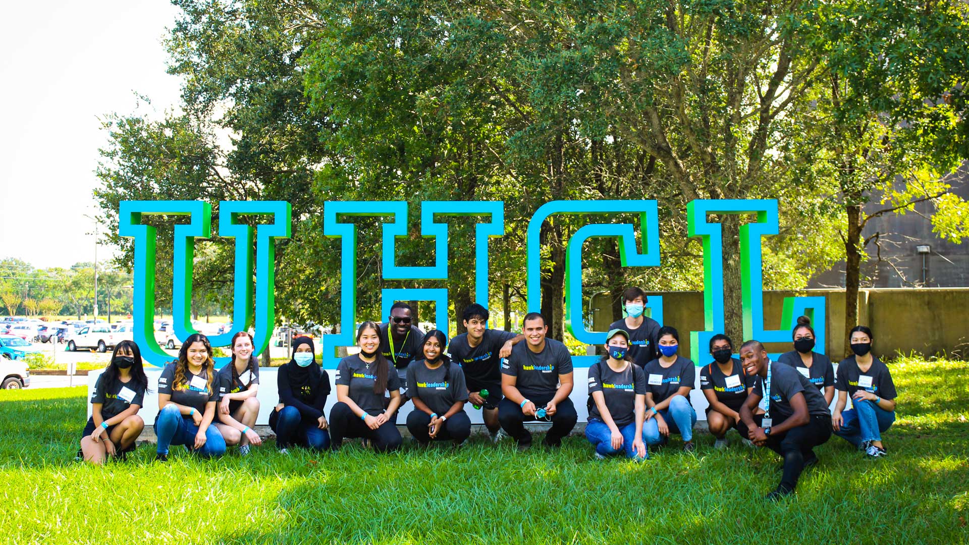 Students gathered in front of the UHCL letters
