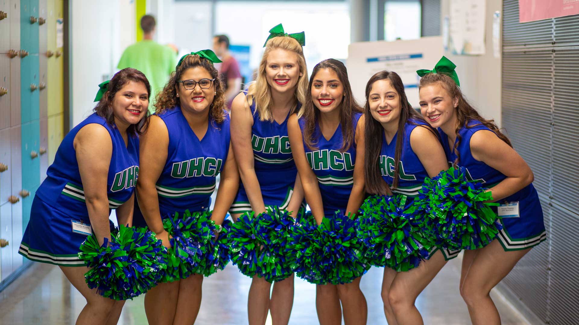 Spirit Squad smiling in blue and green uniforms