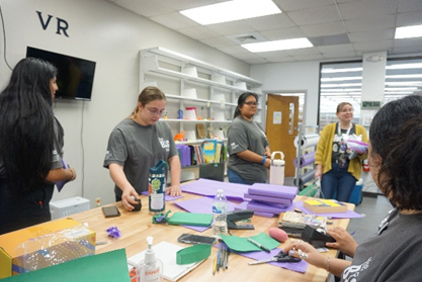 Community engagement activity showing group of UHCL students working around a table