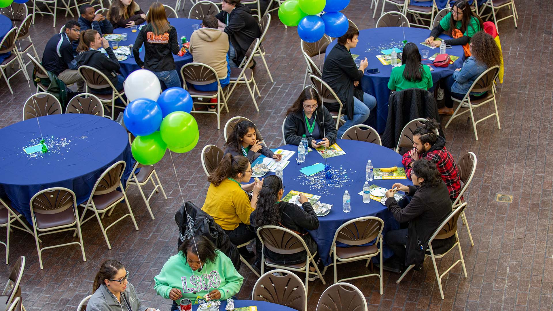 Students gathered at blue and green tables